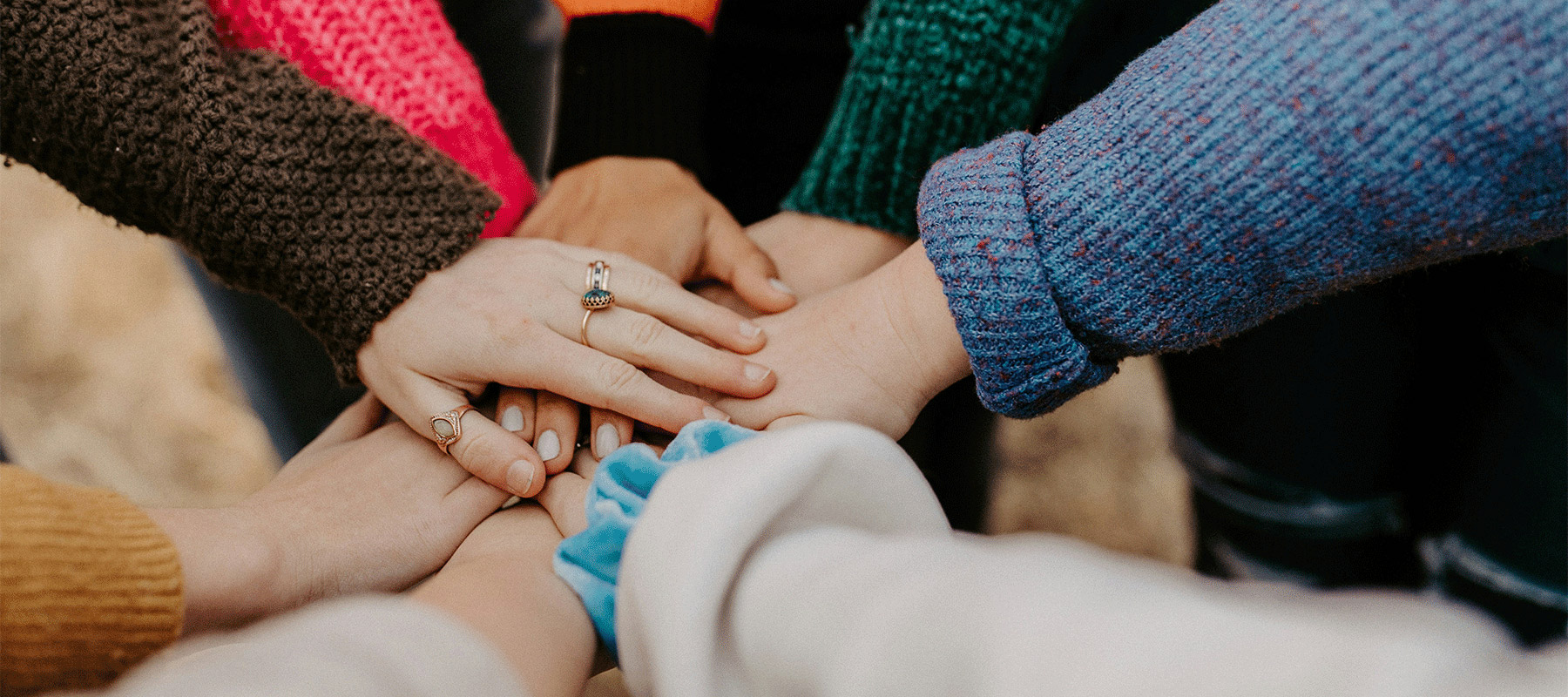 People stacking their hands on each other.