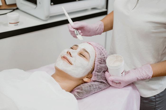 esthetician puts mask on client