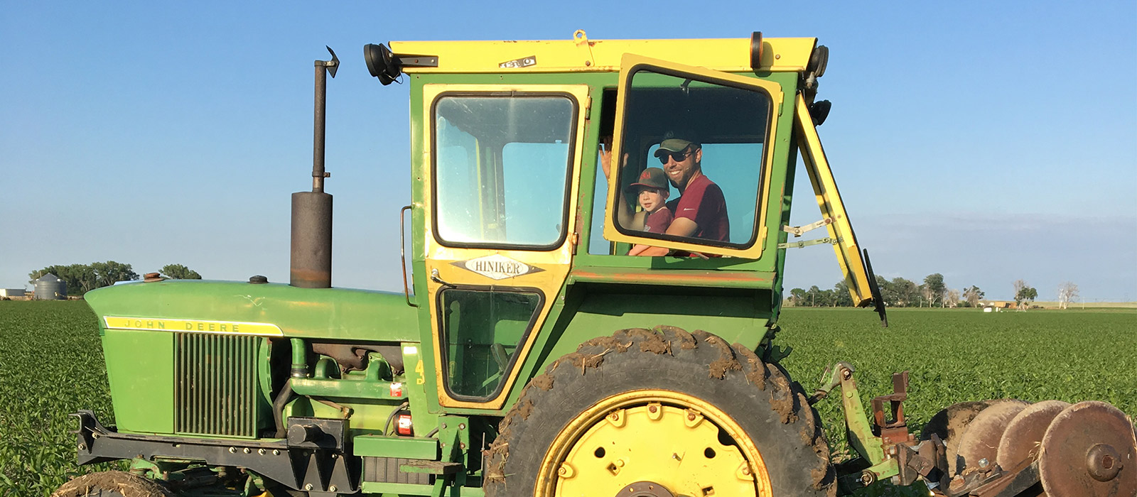 Andy Bartlett and son in a tractor in a field