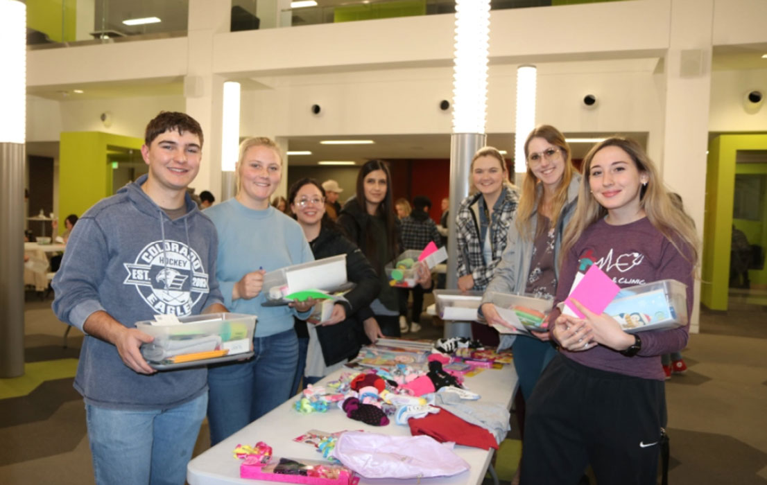 Northeastern Junior College students hold up boxes being packed for Operation Christmas Child during a box packing party hosted by NJC’s Phi Theta Kappa Honor Society Tuesday, Nov. 15, 2022.