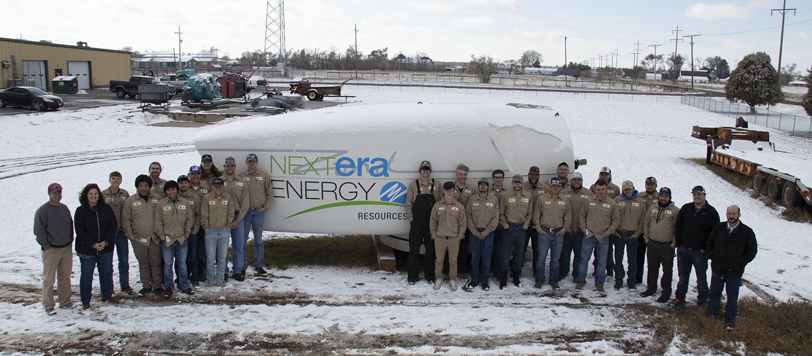 Students and representatives from Nextera Energy posing in front of a nacelle.