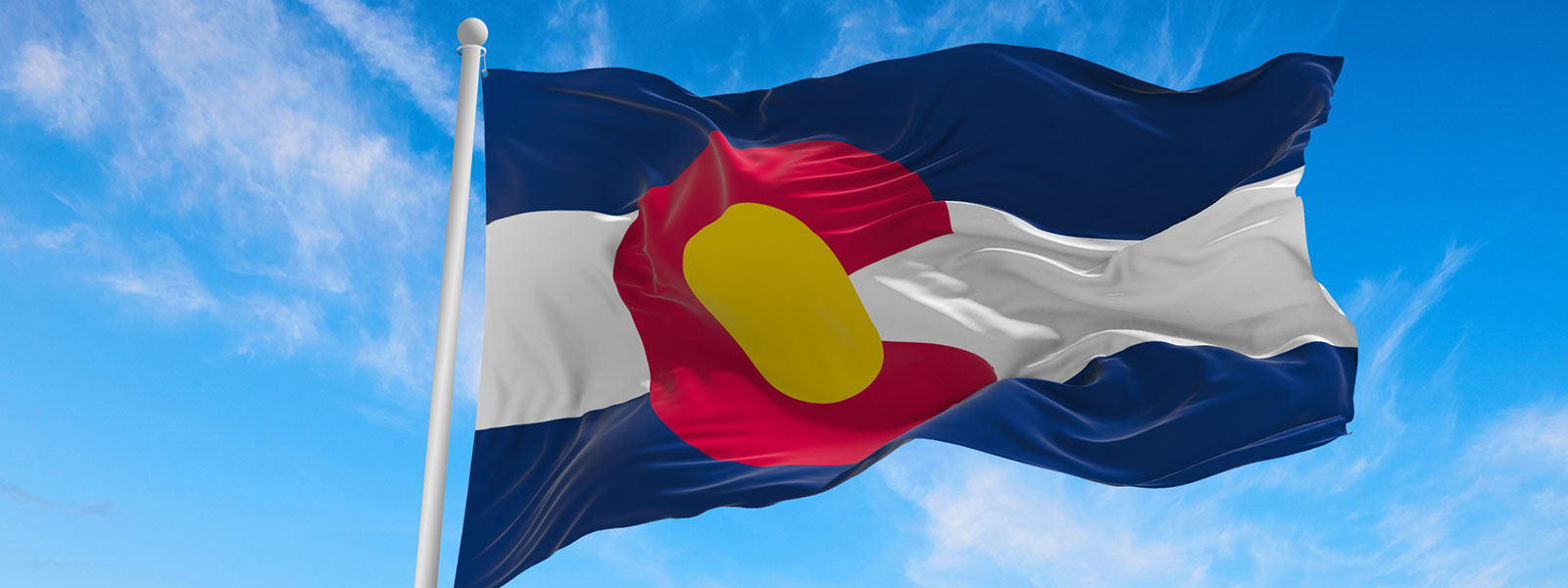 Colorado flag flying with a blue sky in the background
