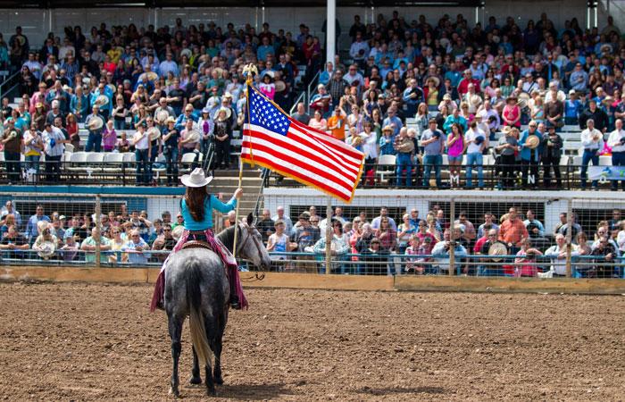 Woman on a horse holding an American flag
