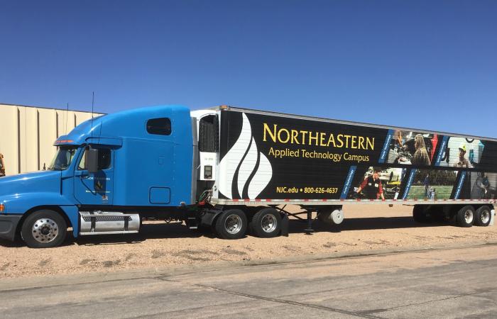 Blue semi truck with black NJC trailer 