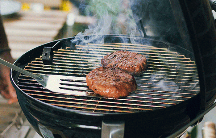 Hamburgers grilling on a grill.