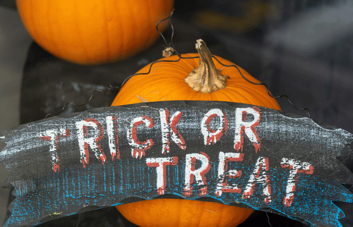 sign saying Trick or Treat with pumpkins in the background