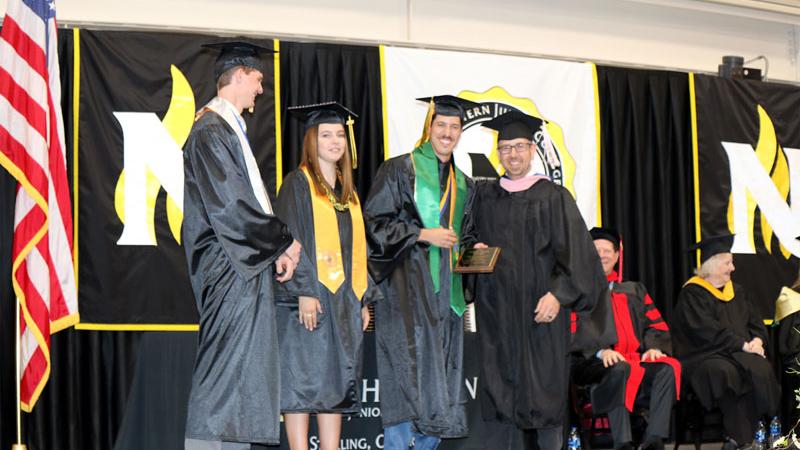 Northeastern Junior College Associated Student Government First Vice President Joao Fonseca presents the Joel E. Mack Award to Lee Lippstrew, right, at the commencement ceremony Friday, May 12, 2023. Joining them are ASG President Philip Ruch and Second Vice President Audrey Glynn.