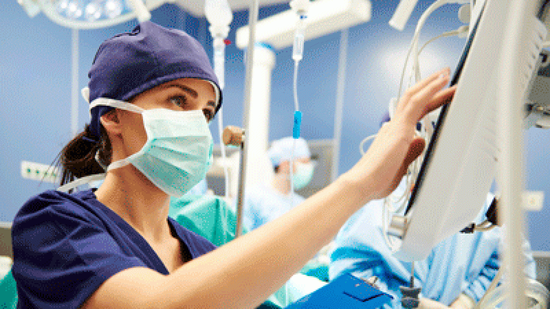 Nurse working on medical equipment