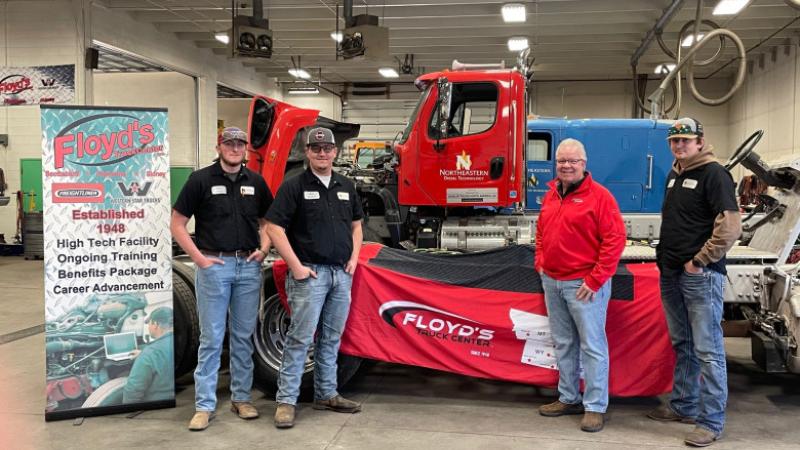 Mark Felker, second from right, and several Northeastern Junior College diesel technology students pose for a photo with some of the trucks and equipment that the company has donated to the program over the years.