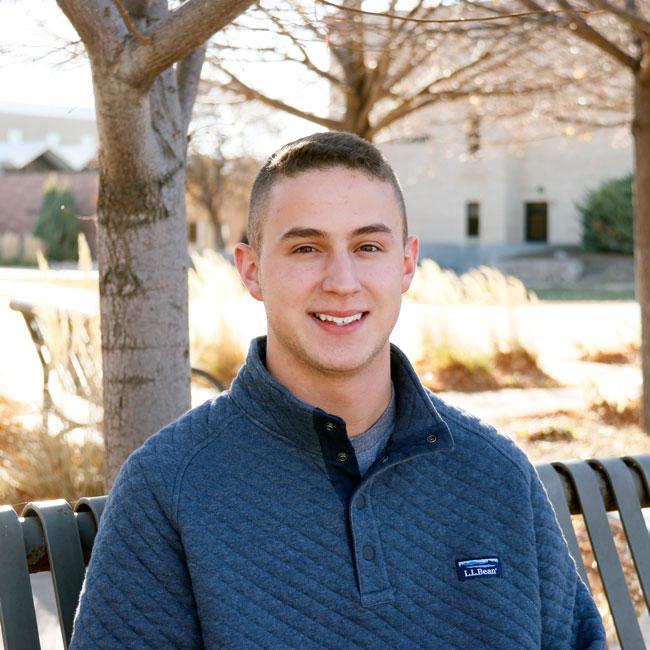 Cooper Dewitt sitting on a bench at Northeastern Junior College