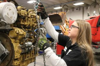 female diesel mechanic lifting engine