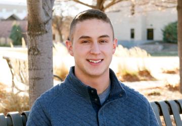 Cooper Dewitt sitting on a bench at Northeastern Junior College